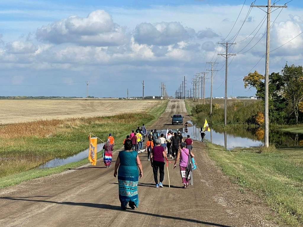 Buffalo People Arts Institute Tatanga Skull Walk along a grid road. 